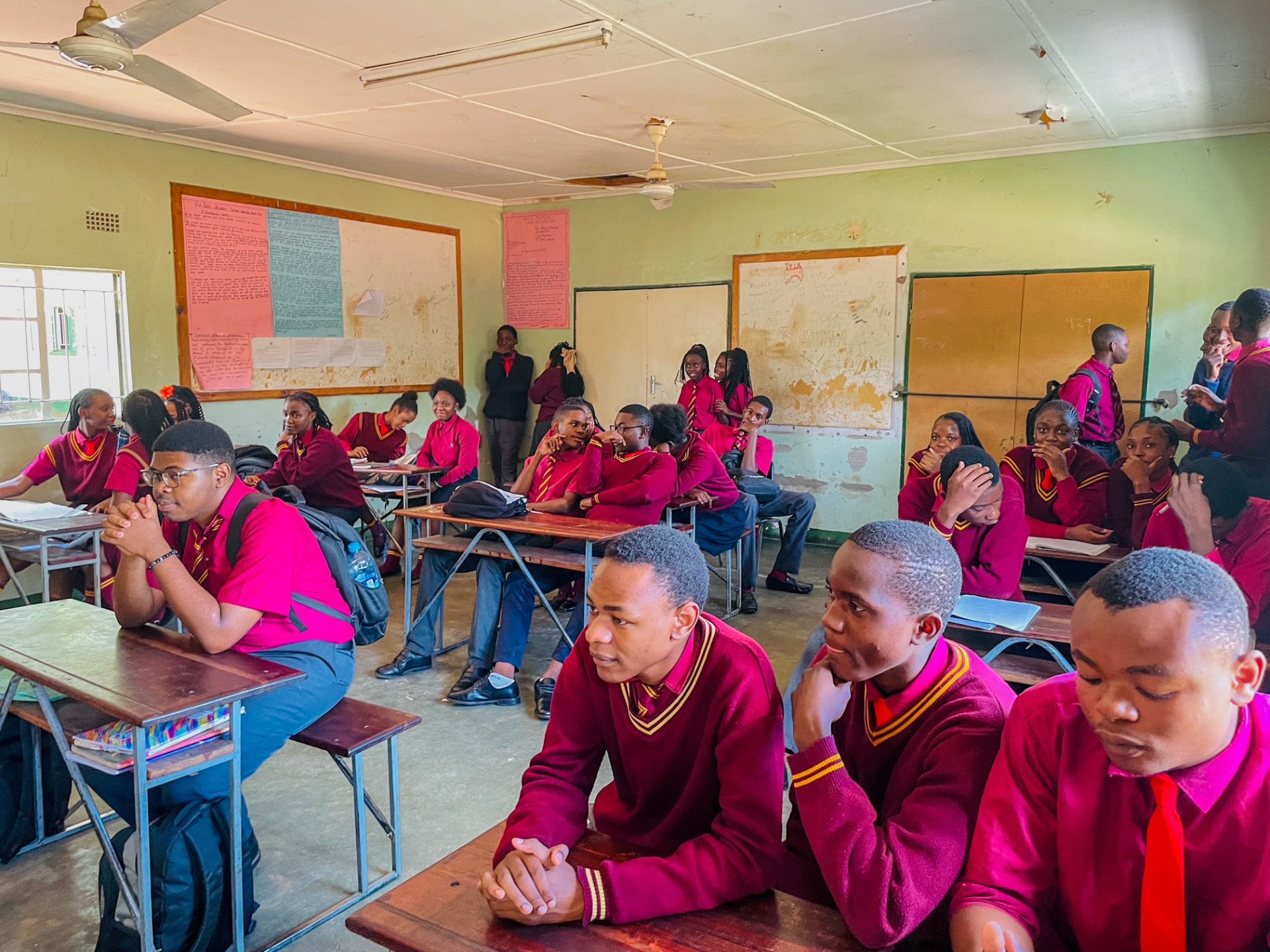 A full classroom of pupils in red uniforms