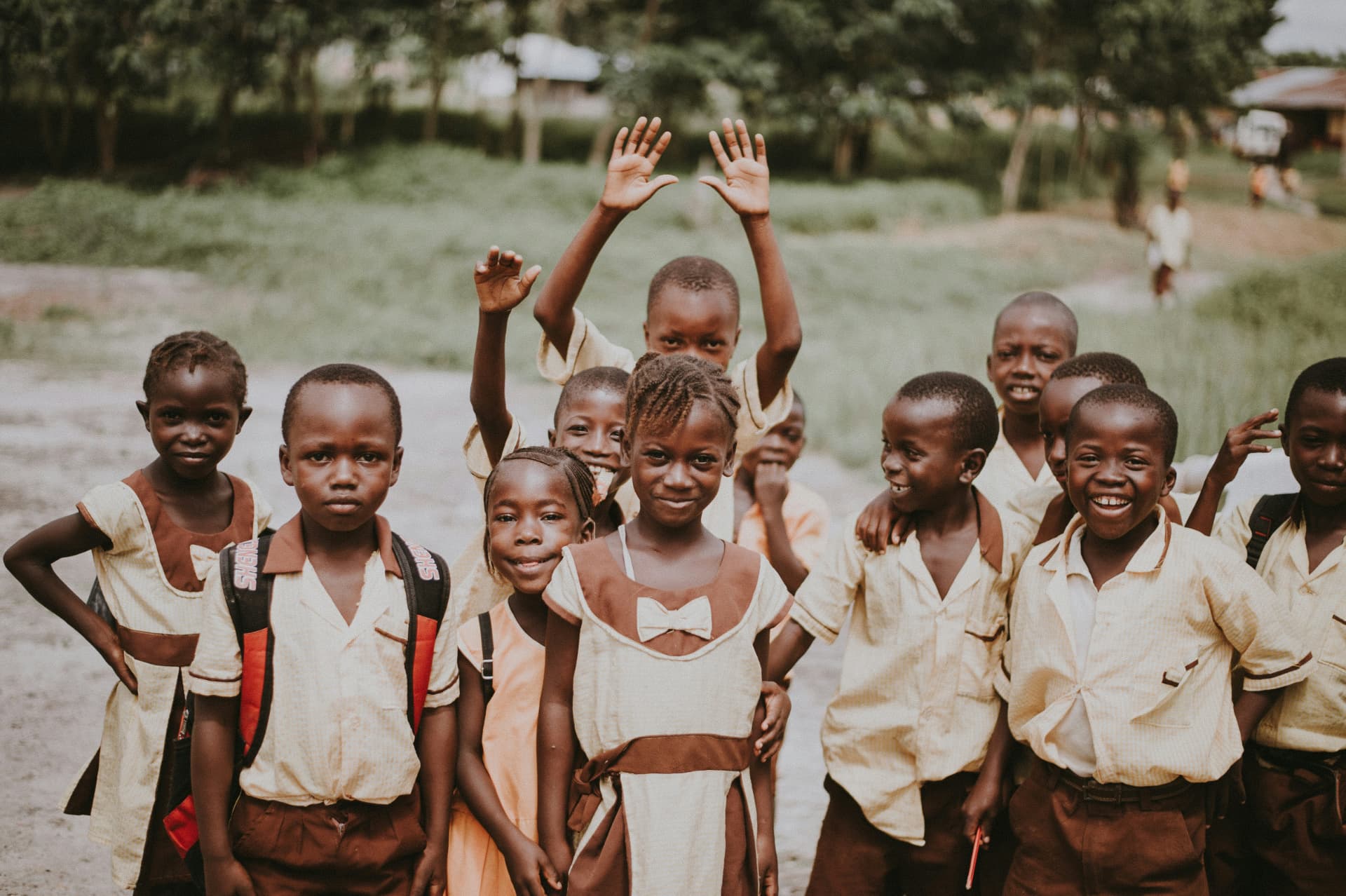School children in uniform waving happily