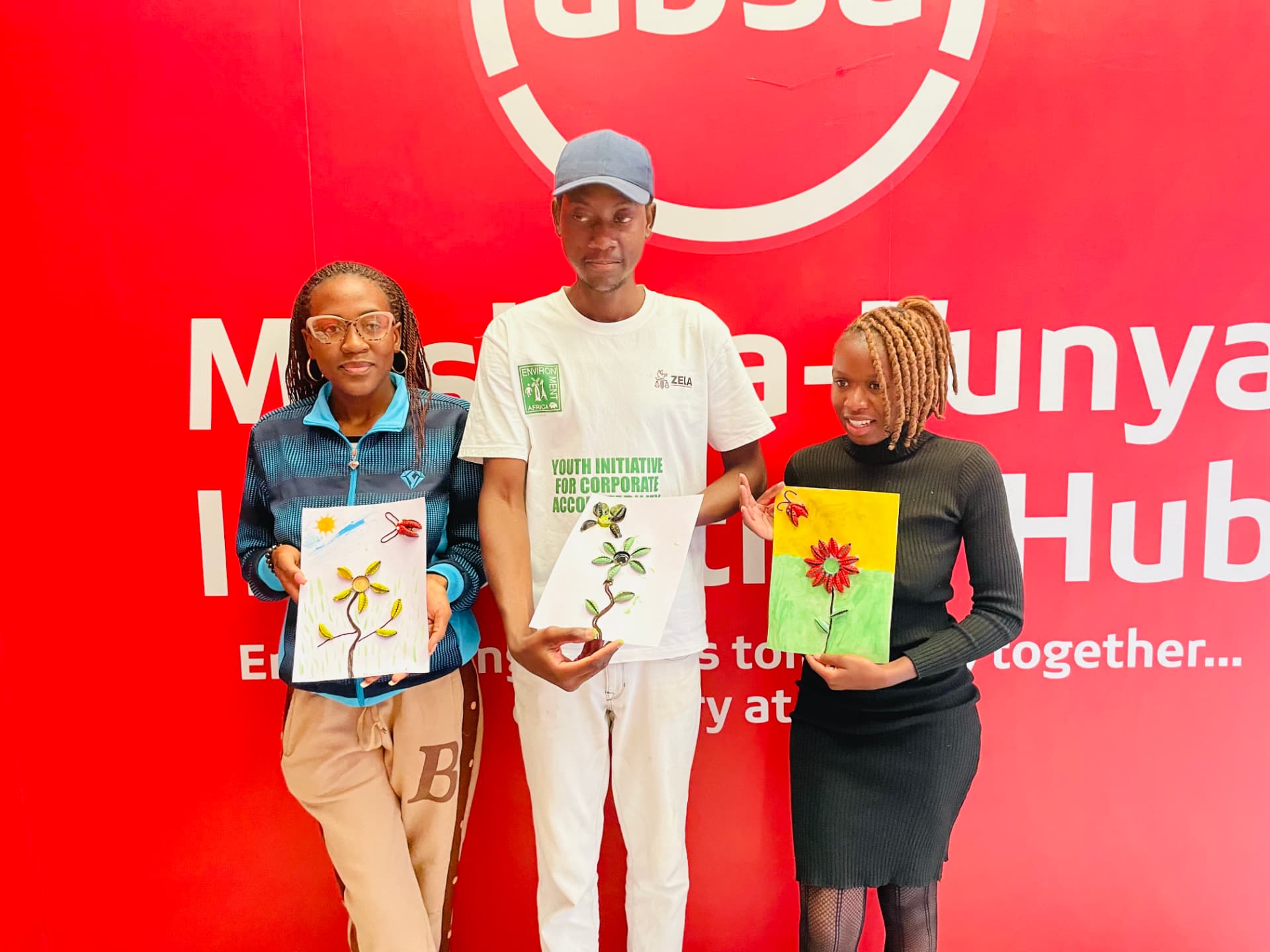 Three young people holding leaf artwork