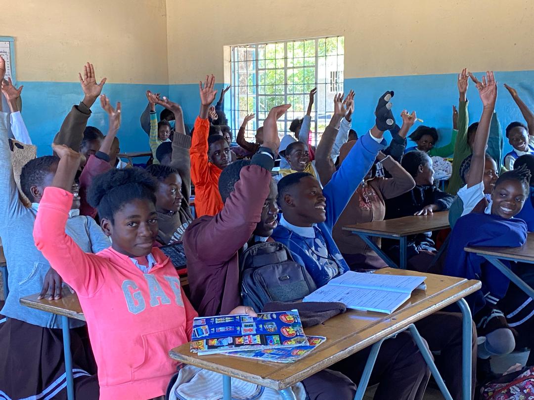 Pupils raising their hands during a climate lesson